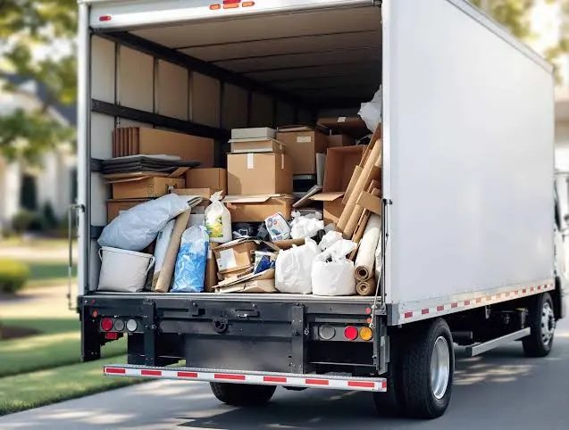 Open box truck loaded with cardboard boxes, bags and rolled materials