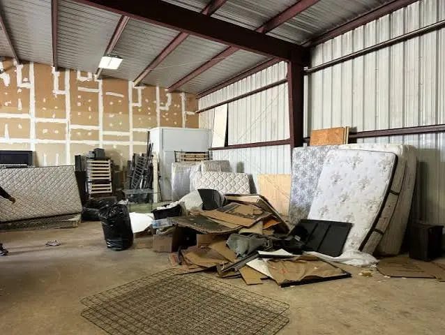 Warehouse bay with old mattresses, flattened cardboard and leftover materials